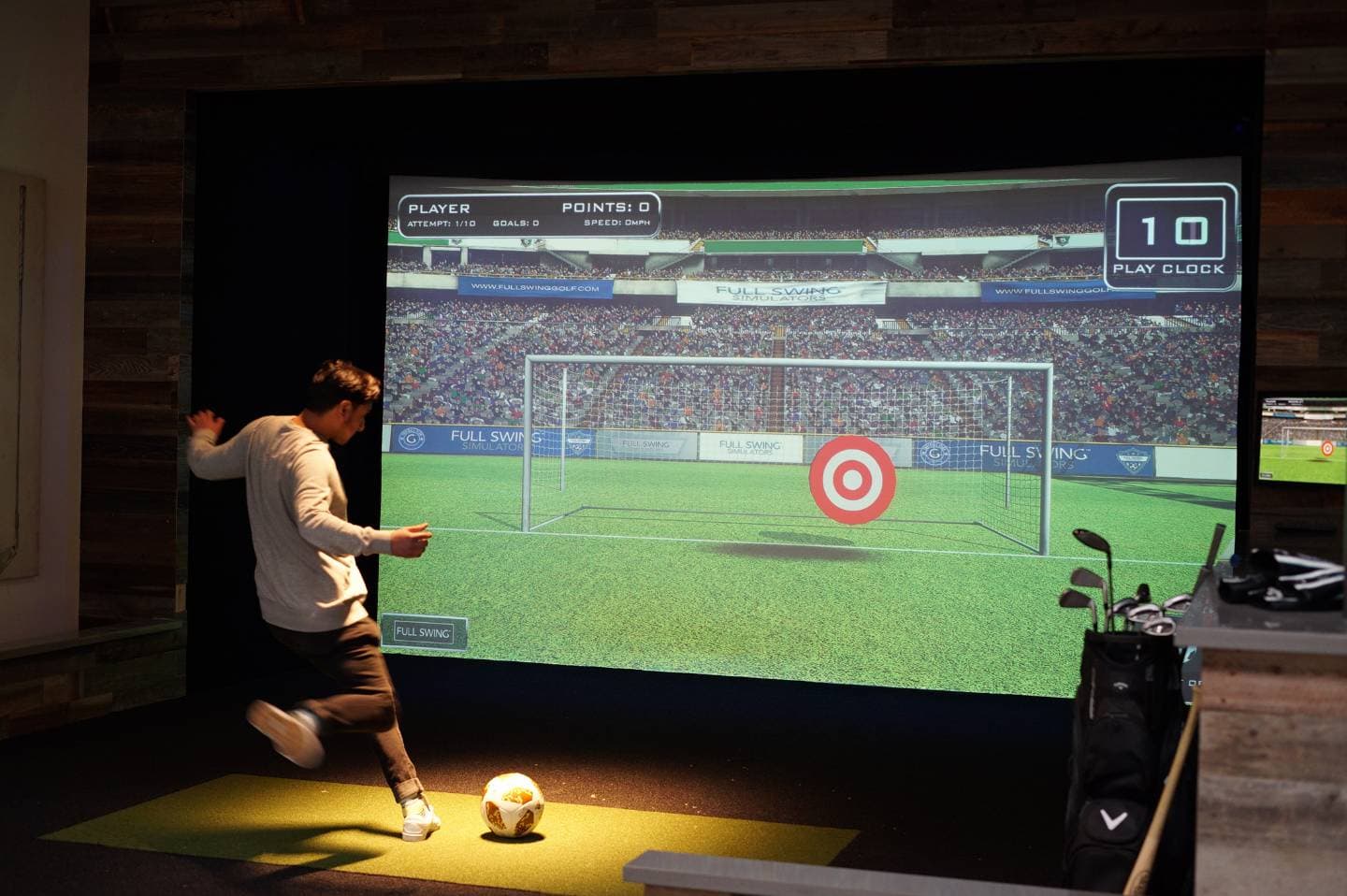 A player running up to strike a football at a target set in the goalmouth shown on the simulator screen.